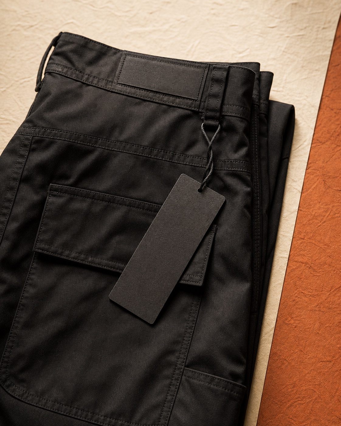 Mockup detail celana hitam terlipat dengan hangtag